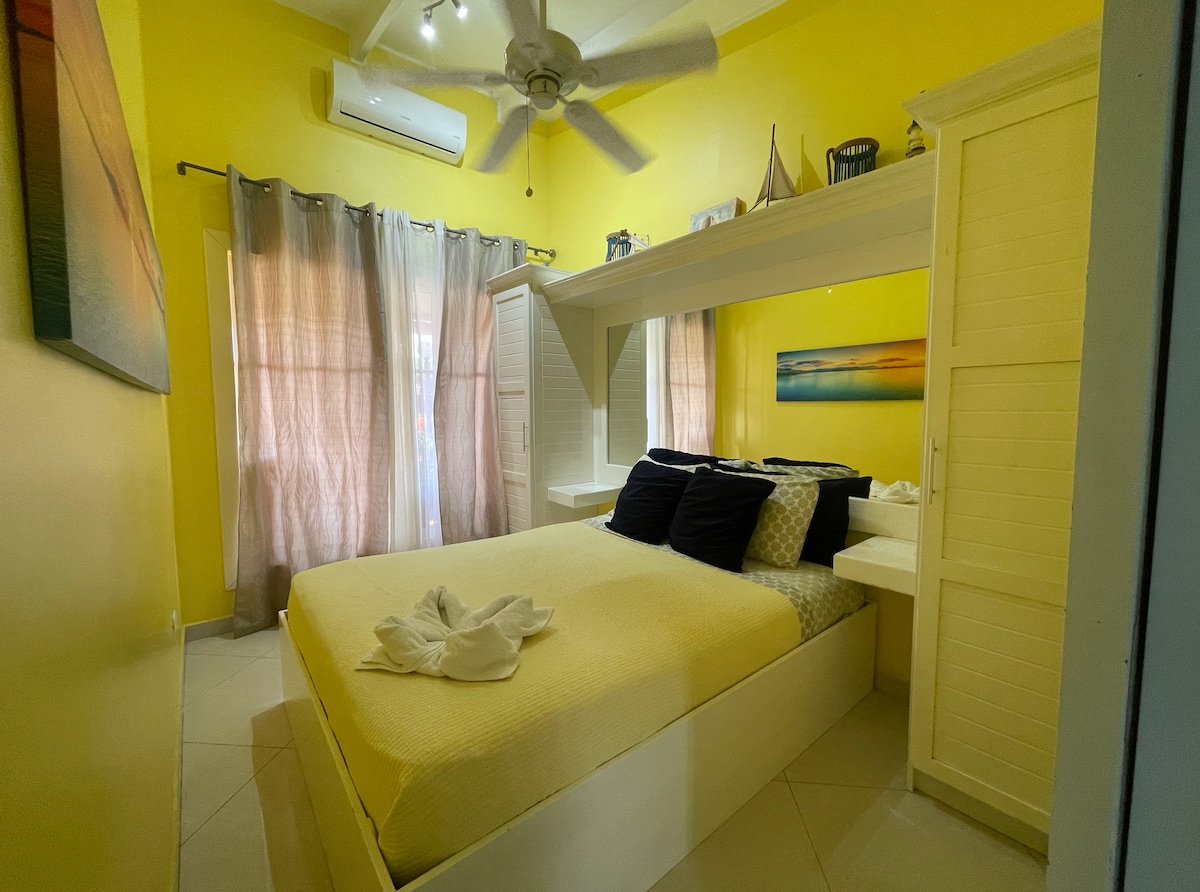 Hlavná spálňa má manželskú posteľ, dostatok úložného priestoru, klimatizáciu a veľké okno. 