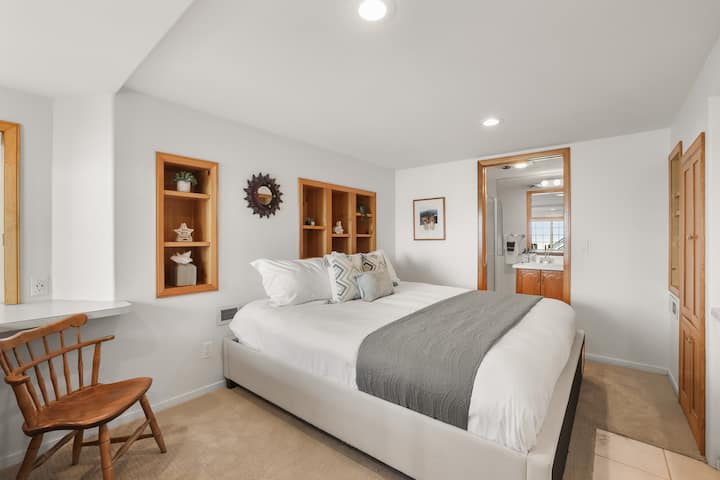 Cómodo dormitorio King con muebles empotrados e iluminación cálida.