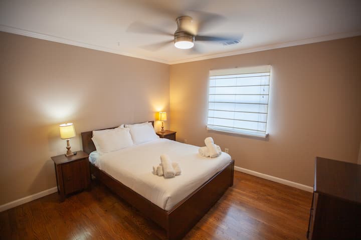 Un acogedor dormitorio en la planta baja con una lujosa cama tamaño queen, mesitas de noche con lámparas de lectura y un armario privado. El refugio perfecto después de un largo día de turismo, que ofrece comodidad y tranquilidad.