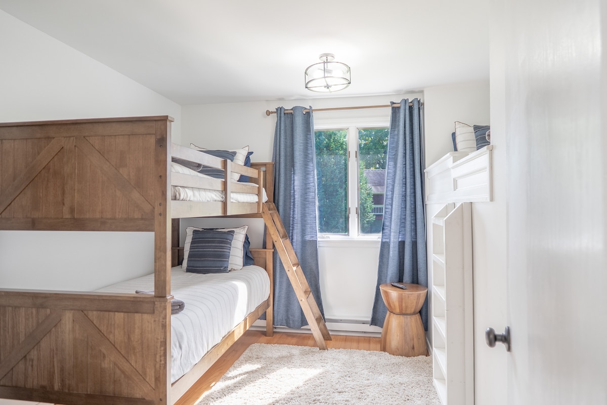 غرفة بطابقين في الطابق الرئيسي بسريرين بطابقين وسرير علوي مزدوج مع سلم جداري للوصول إليه. (إجمالي 3 أسرّة مزدوجة)