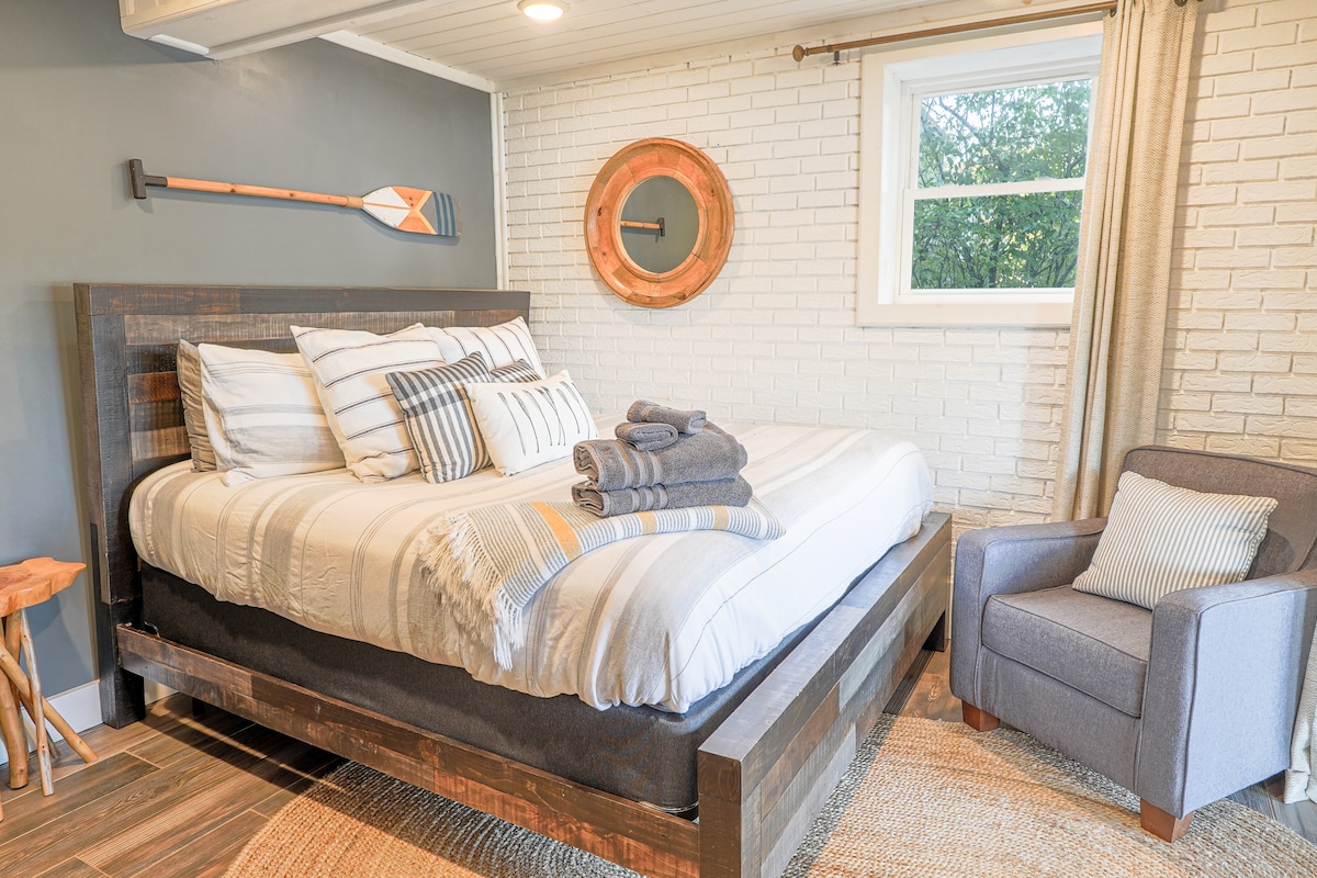 غرفة نوم بسرير كينج في الطابق السفلي. يمكنك المشي إلى الفناء مع مدخل خاص. إطلالات خلابة على البحيرة.