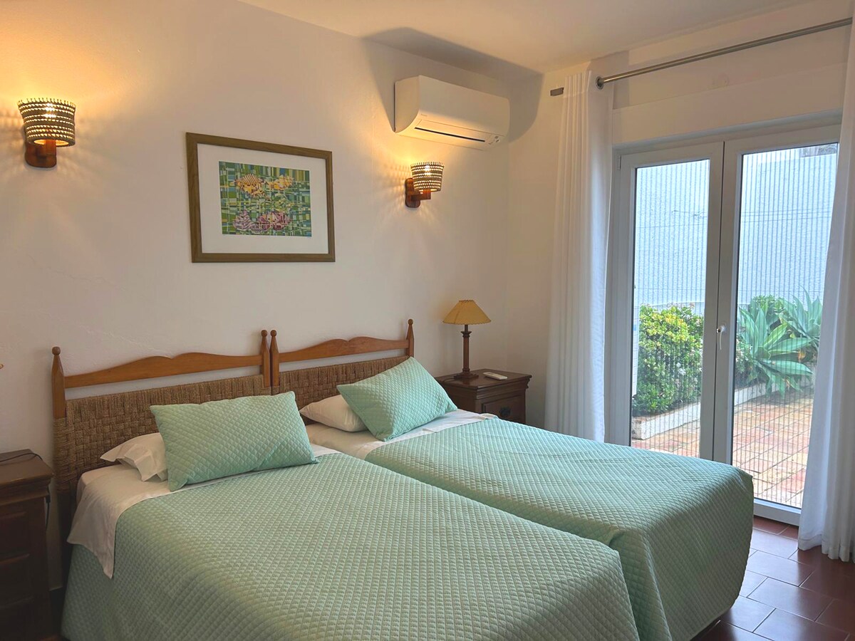 Spavaća soba 2 ima dva odvojena kreveta, ugradbeni ormar i vrata na privatnu terasu u blizini bazena 