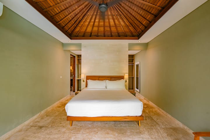 The #2 bedroom at Kejora 5 features a king bed, a spacious wardrobe, and an ensuite bathroom, along with direct views of the pool and garden.