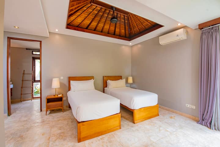 Room #4 offers a spacious layout with two single beds that can easily be converted into a double if needed. It also features an ensuite bathroom and views of the pool and garden.