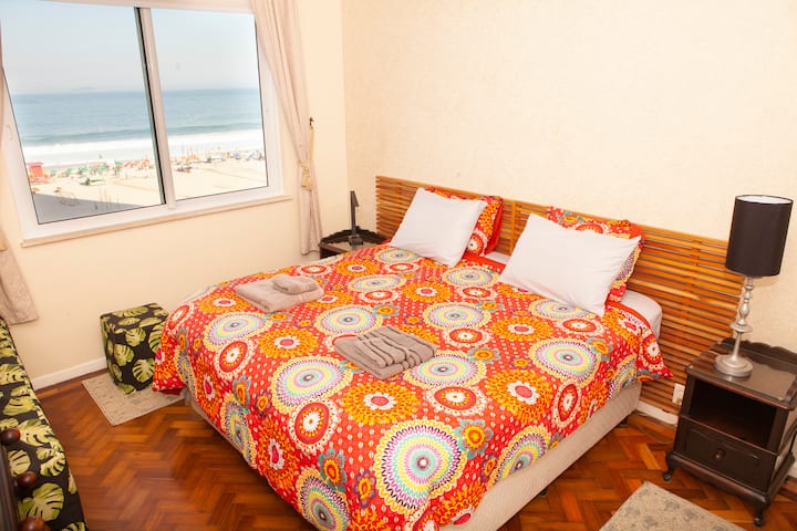 Quarto 1 (quarto principal) com vista completa para a praia e para o mar, cortinas escuras, janelas com isolamento acústico de 3 panos para uma melhor noite de sono e um carregador/lâmpada sem fio combinado.

