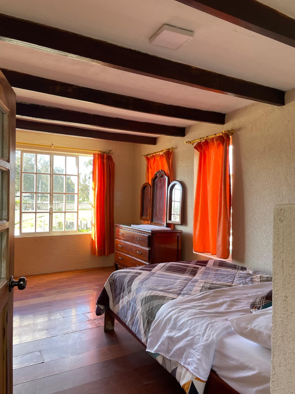 Cálida habitación matrimonial con estilo rustico.
Ofrece cama, velador y espacios para almacenar ropa.