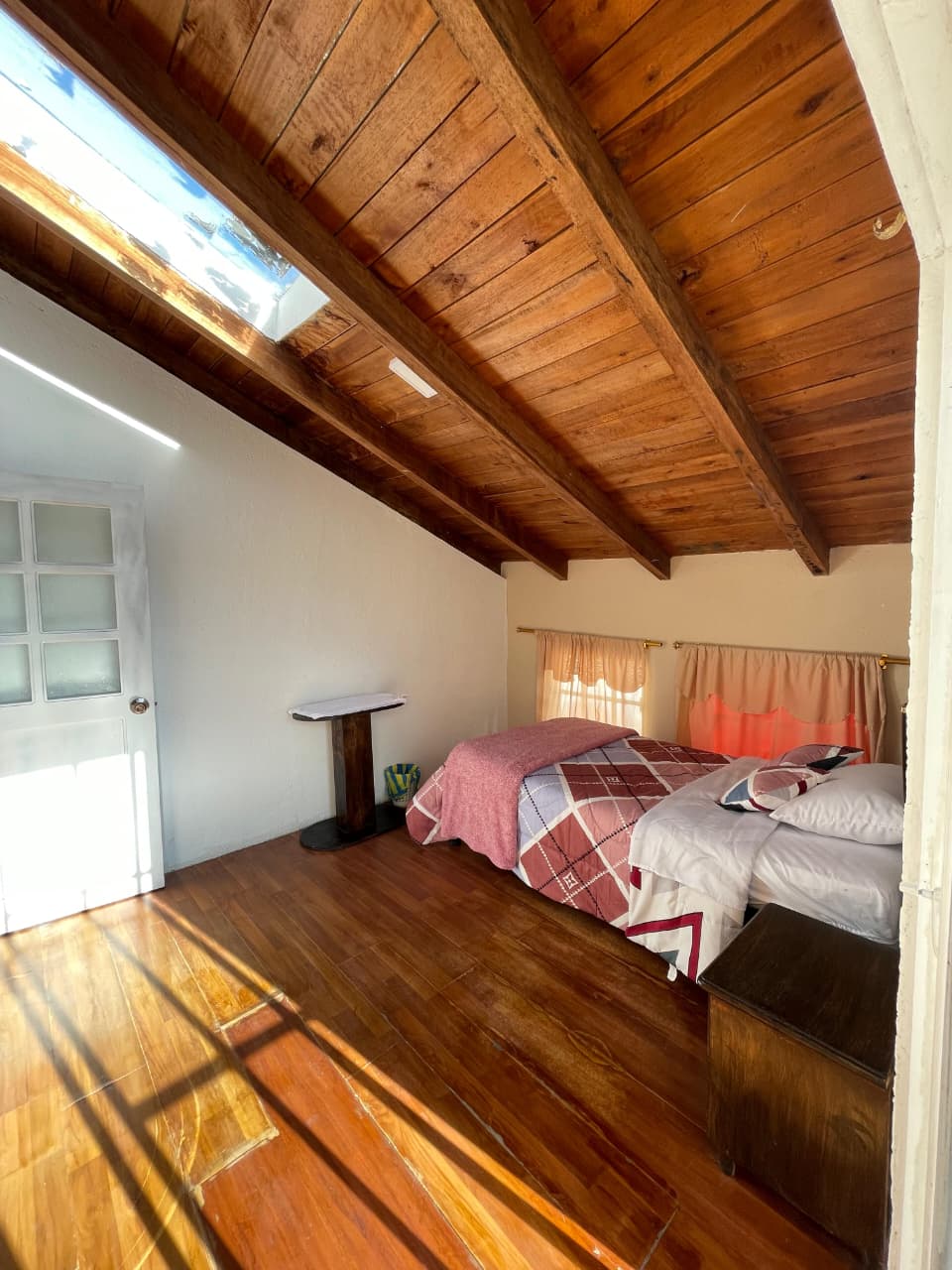 Hermosa habitación de estilo rústico que cuenta con acceso a su propio balcón.
Tiene cama de plaza y media, velador y espacio para guardar la ropa.