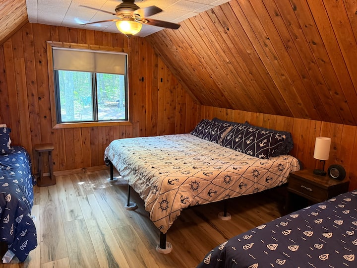 ห้องนอนชั้นบนด้านหลังพร้อมเตียงคิงไซส์และเตียงแฝด 2 หลัง