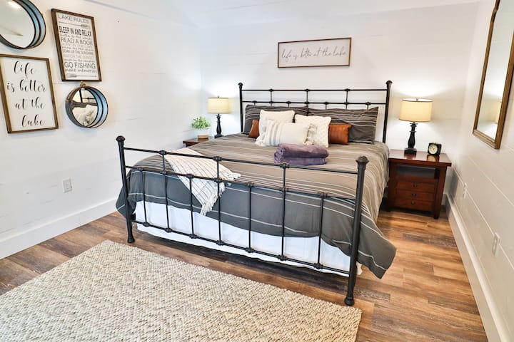 Chumba cha kulala cha msingi kina kitanda cha kifalme chenye sitaha ya kutoka nje, kinachoangalia ziwa.