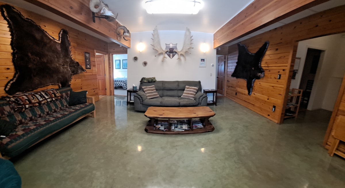 Futon till vänster finns en soffa, men fälls också ut till en dubbelsäng; extra lakan, kuddar och filtar i sängkläder garderoberna. Äkta Alaska-inredning. Utsikten är från det främre fönstret och tittar in.