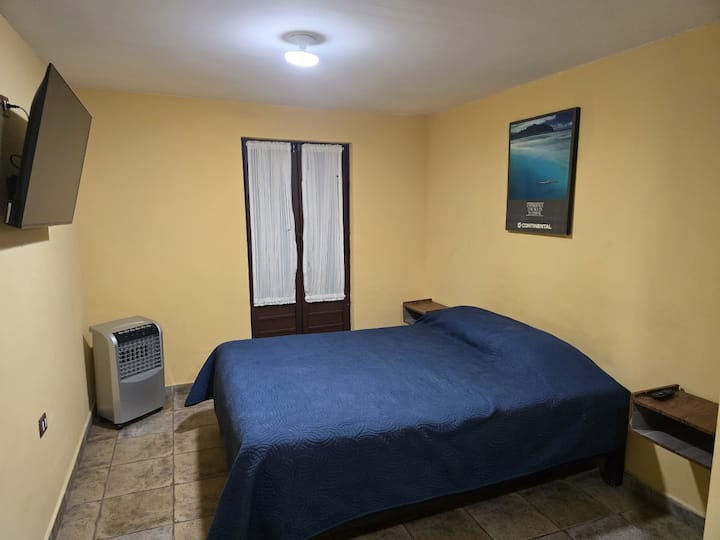 主卧室，配备电视和空调（风扇）