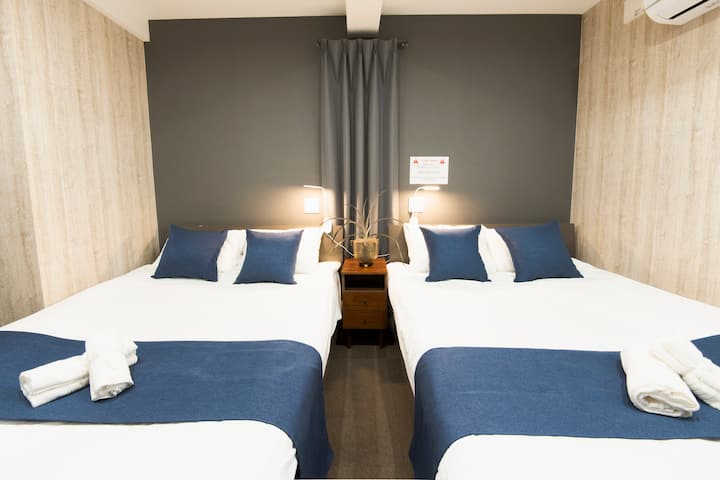 Cette chambre a 2 lits doubles, une douche et une toilette.
