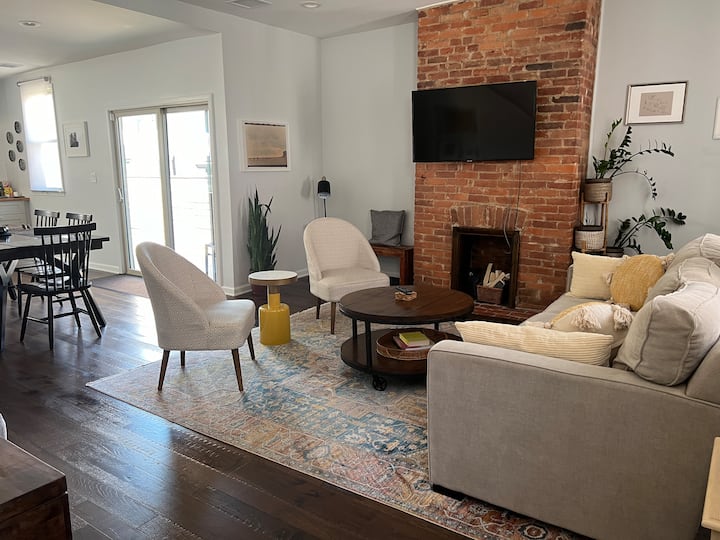View from the front door shows open concept with multiple sitting areas. Sliding glass doors lead to the deck.
