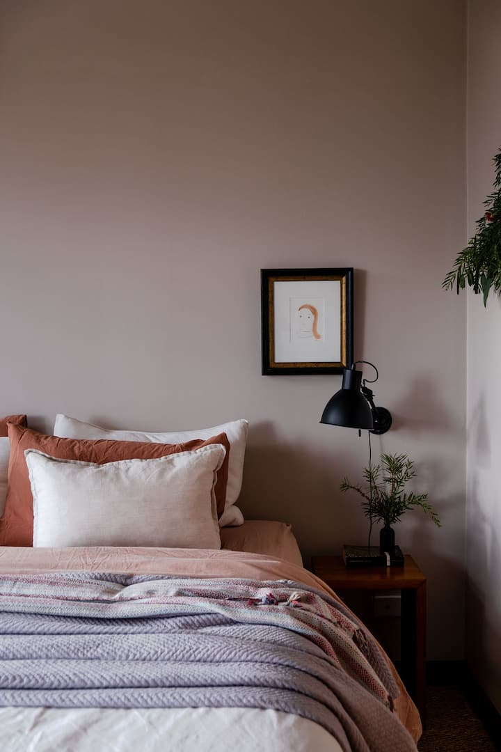 חדר שינה ראשי מרווח עם מיטת קינג-סייז, מצעים חלומיים ונופים מרהיבים לעמק.