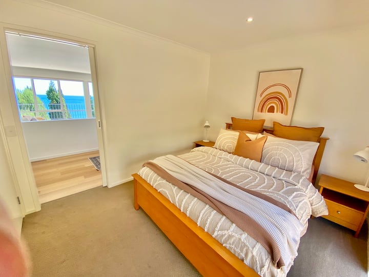 Bedroom two has a queen bed, windows looking out to garden, a robe and a built in desk.