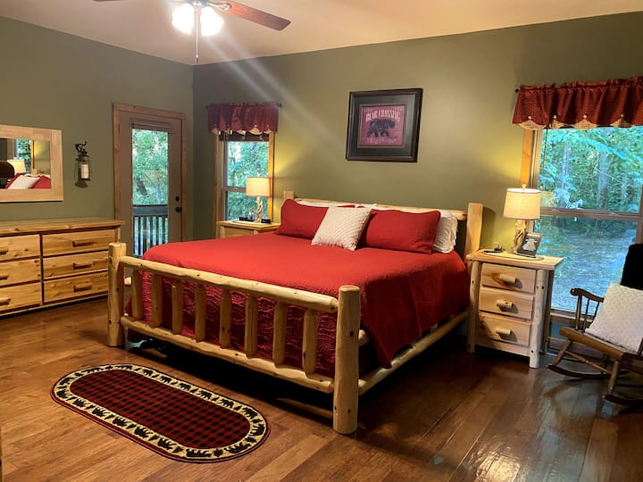 King bed in Main Floor Master Suite. Has Sound Machine, Charging Station, Ceiling Fan, Window Shades, and on suite bathroom.
