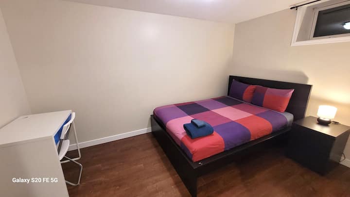 غرفة نوم في الطابق السفلي بسرير مزدوج وصدر بجانب السرير ومكتب عمل