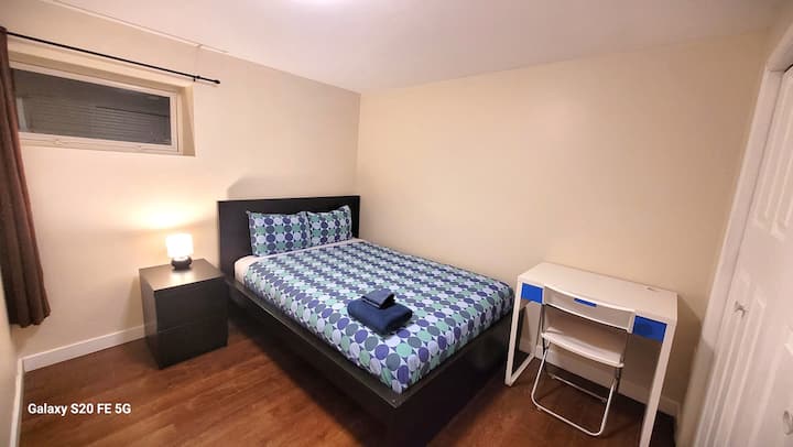 غرفة نوم في الطابق السفلي بسرير مزدوج وصدر بجانب السرير ومكتب عمل