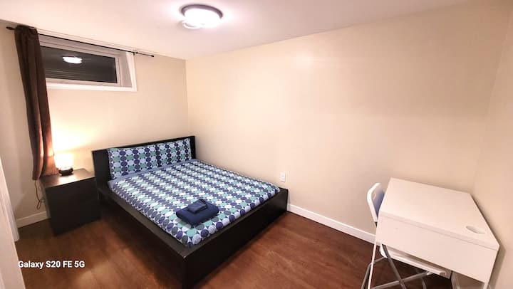 غرفة نوم في الطابق السفلي بسرير مزدوج وصدر بجانب السرير ومكتب عمل