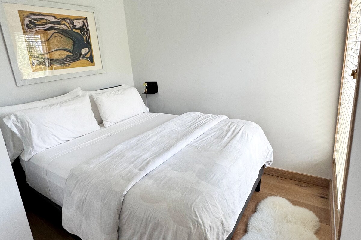 Cama tamaño queen en casa de huéspedes privada con vistas relajantes a la piscina y al comedor al aire libre