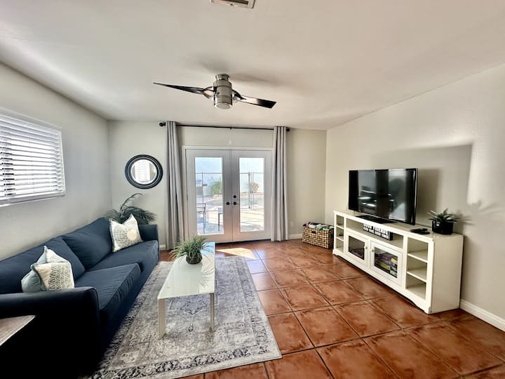 Den met queensize slaapbank, tv en openslaande deuren naar California Room en achtertuin