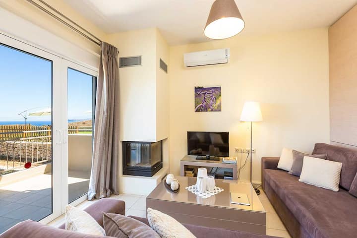 ヴィラ1の1階：豪華なソファ、32インチ衛星HDテレビ、居心地の良い暖炉を備えたオープンプランのリビングエリア。