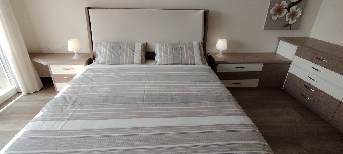 מיטת קינג סייז עם שמיכת פוך וכריות זיכרון.