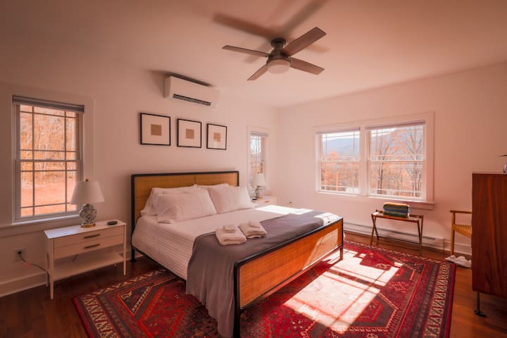 The primary bedroom featuring a king bed, blackout shades, and an en-suite bathroom

All bedrooms feature a Dohm white noise machine, ceiling fan, and custom climate control. 