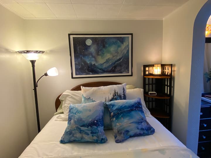 Full size antique bed, featuring my energy art on the pillows and blankets. I have had at least 10 guests tell me they have had the best night sleep they have ever had in this bed. It's magic!