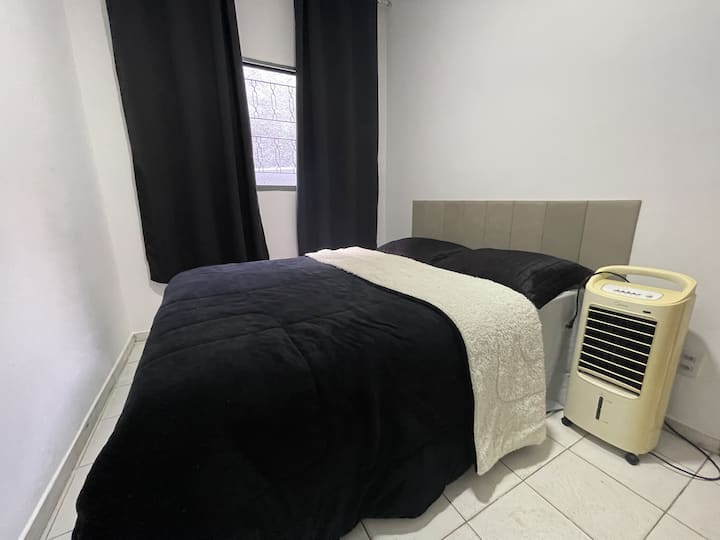 غرفة نوم مزدوجة مع سرير صندوقي واحد ومروحة ومرطب هواء وتعتيم