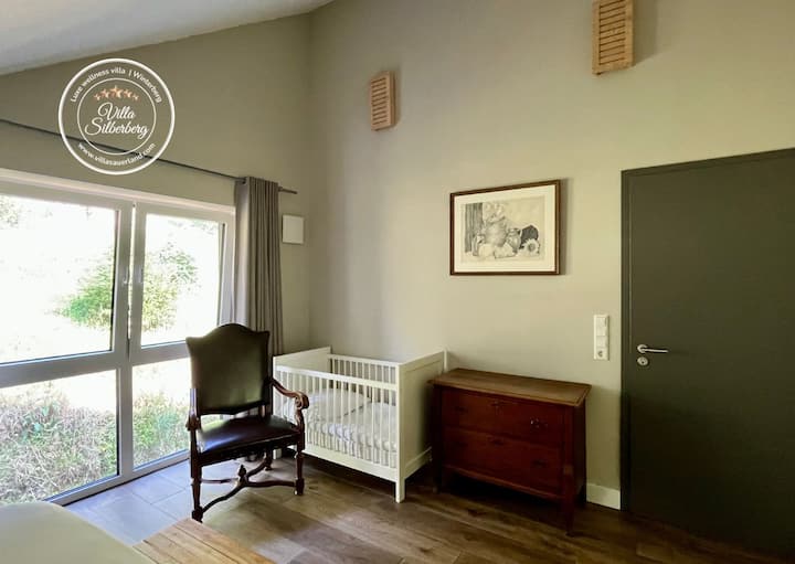 غرفة نوم في الطابق العلوي مع سرير مزدوج مع نوابض وعلبة وسرير أطفال. 