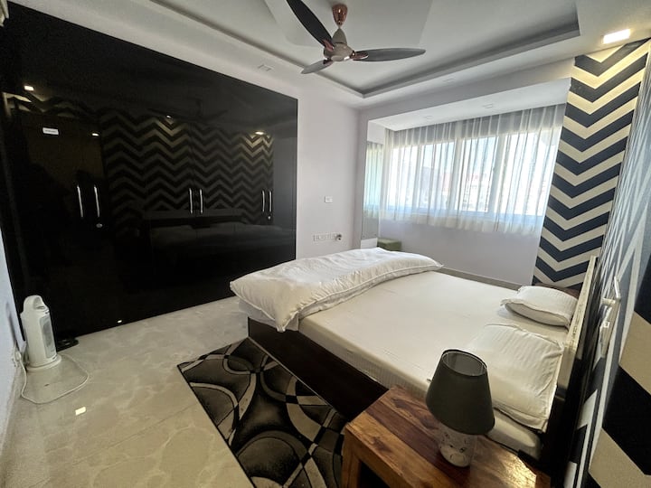 prostrana spavaća soba s ormarom i pripadajućom kupaonicom s pogledom na park 