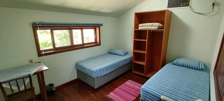 这间客房可俯瞰后院和Lampião山。 木地板。有空调。 一条小动脉和一张带椅子的桌子。 床是盒式的，窗户上有纱窗和百叶窗。