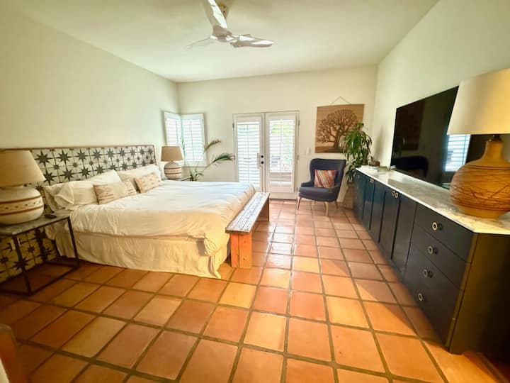 Primary Bedroom with 62" hdtv. Cal King Bed. Double French Doors leading to outside.