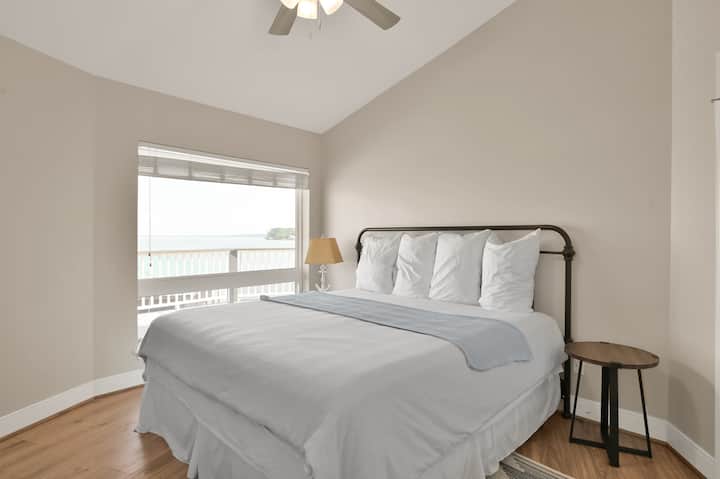 Chumba kikuu cha kulala kina kitanda cha kifalme, meza mbili za mwisho, kabati la kujipambia na televisheni ya skrini tambarare-unda mapumziko yenye nafasi kubwa na ya kupumzika yenye kila kitu unachohitaji ili kupumzika kwa starehe.
