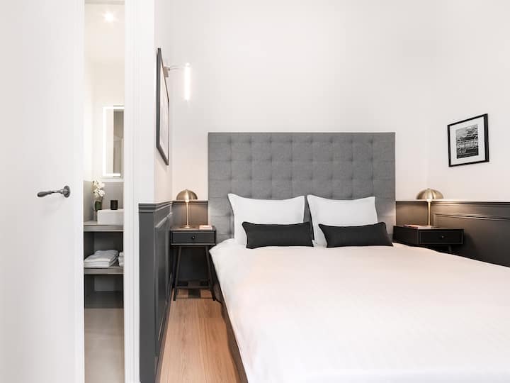 第二间卧室配备双人床、套房浴室、床上用品、空调和宁静庭院的景观