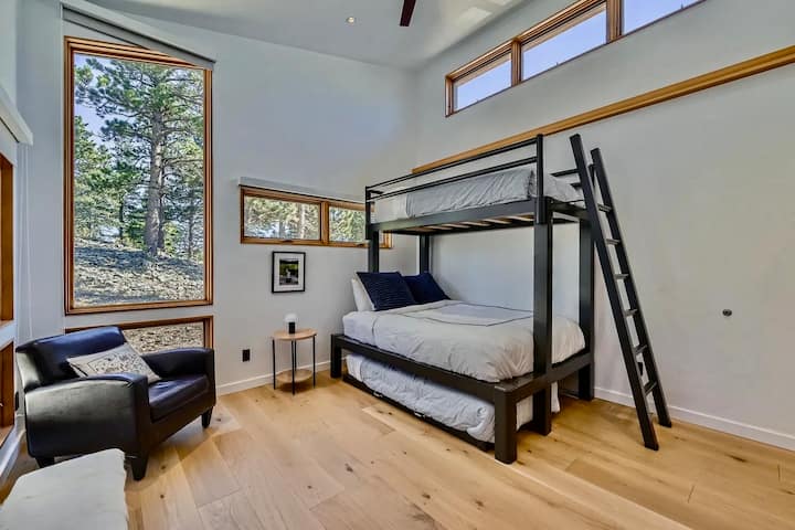 Amplia habitación con literas con cama doble, rincón de lectura y vistas al bosque