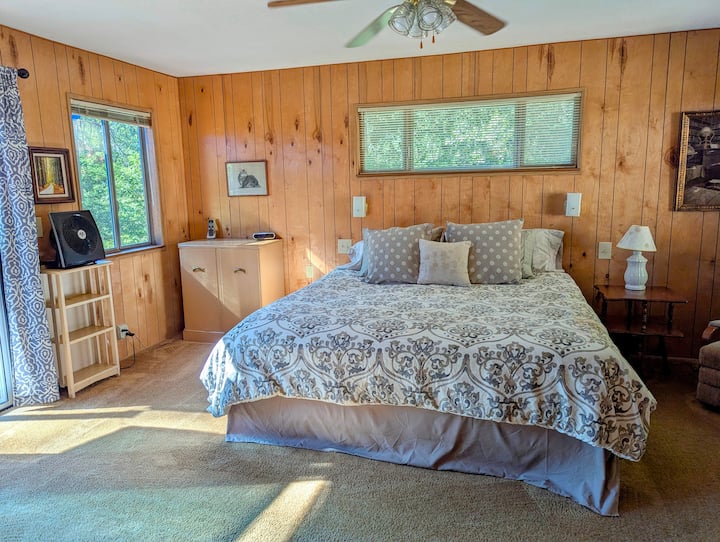 Grande chambre principale aérée avec lit king size.