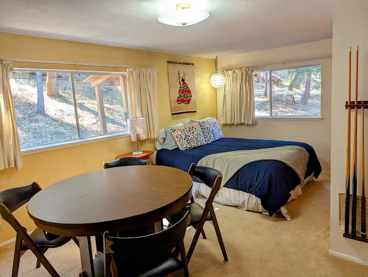 Chambre flexible avec lit queen size et table de billard convertible.