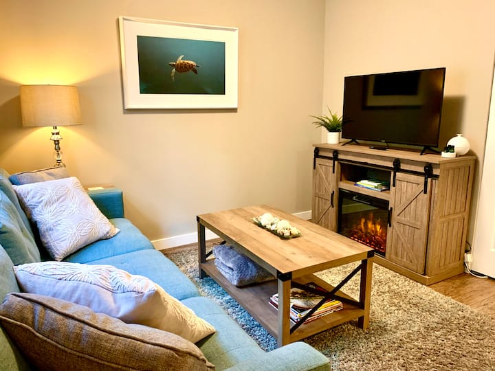 Cozy Living room with comfortable sofa, rocking chair, infrared fireplace and adjustable heat.
