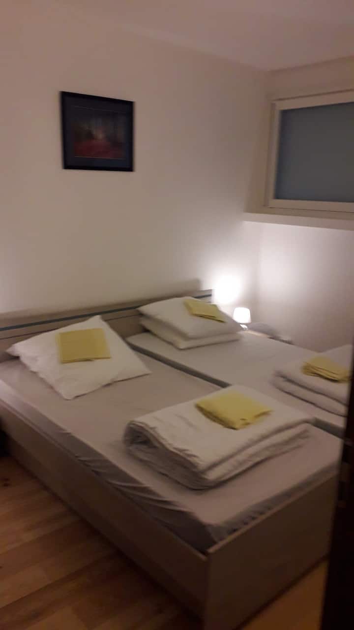 Vue partielle de la chambre cooconing au RDC avec ses 2 lits, chevets, grande armoire et ses nombreuses B.D...2 baies coullissantes.
