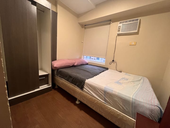 2nd level common room equipped double size bed  and wardrobe with a nice city view.
