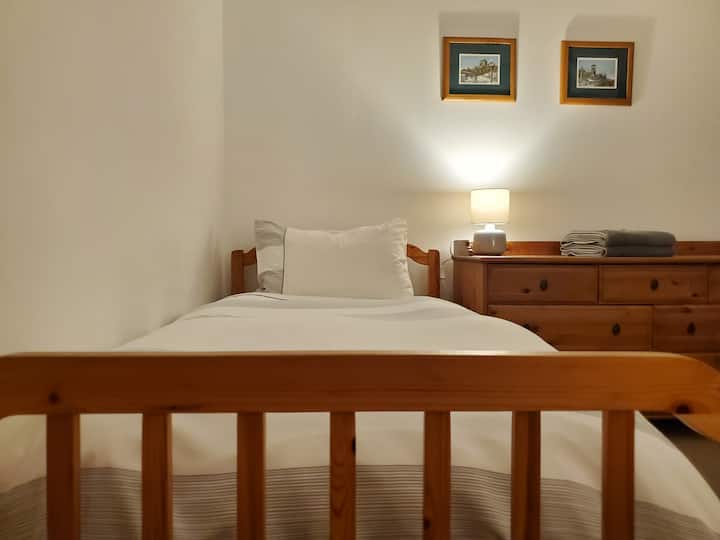 The second bedroom comfortably sleeps 2 in a pair of twin / single beds