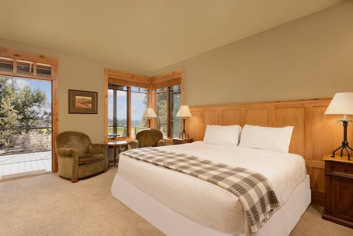 Bedroom 4 - Equipped with a plush king bed, closet for storage, workspace, a small seating area, flatscreen TV, kitchenette, an en-suite bathroom, and patio access.