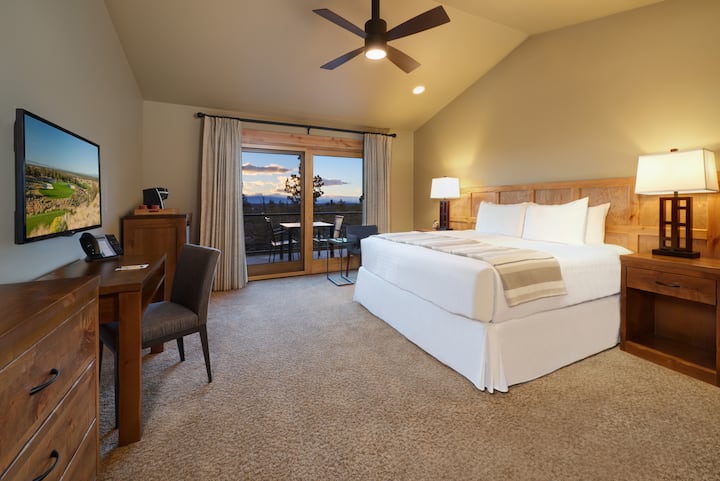 Bedroom 3 - Equipped with a plush king bed, closet for storage, workspace, a small seating area, flatscreen TV, kitchenette, an en-suite bathroom, and patio access.