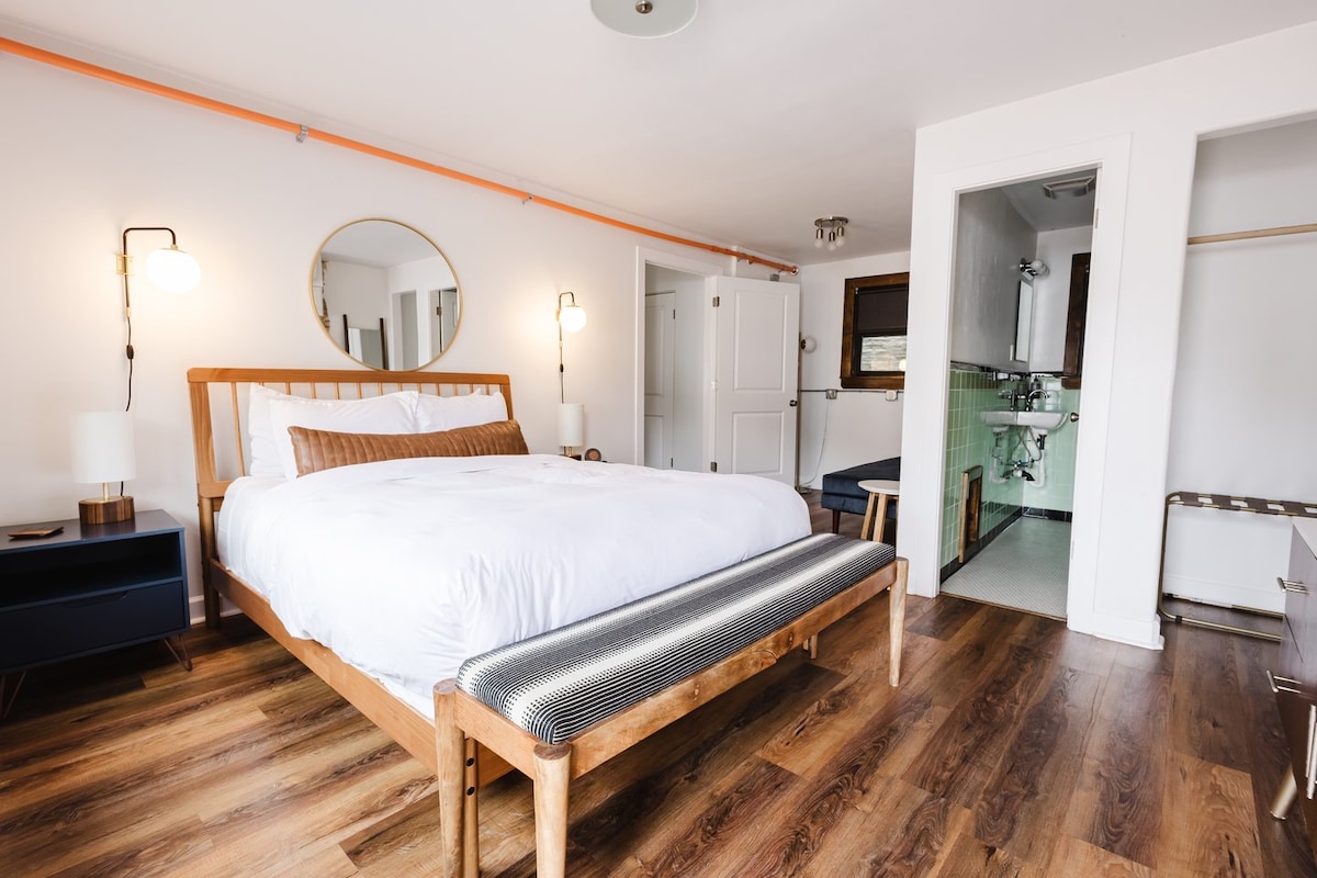 Spálňa s manželskou posteľou Queen, útulný salónik/kútik na čítanie, kúpeľňa a šatníkový priestor s poličkou na batožinu. 