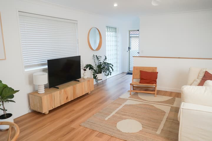 Relájate en esta sala de estar con brisa y llena de luz. Diseñado tanto para la comodidad como para el estilo. Con tonos naturales, asientos acogedores, cortinas de ropa de cama fluidas y un televisor inteligente listo para tu tiempo de inactividad, es un hermoso espacio abierto para relajarte. Now-you-must-sust-stay “namaste”