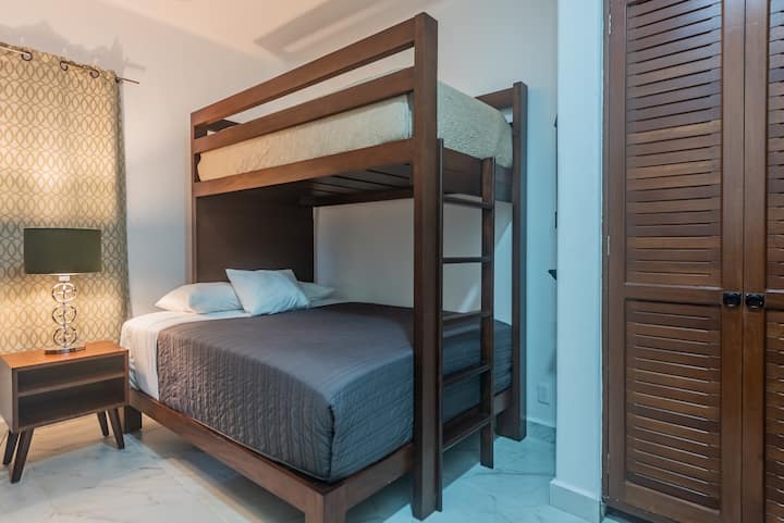 The bottom bed is a queen size bed and the top bed is a singel size bed