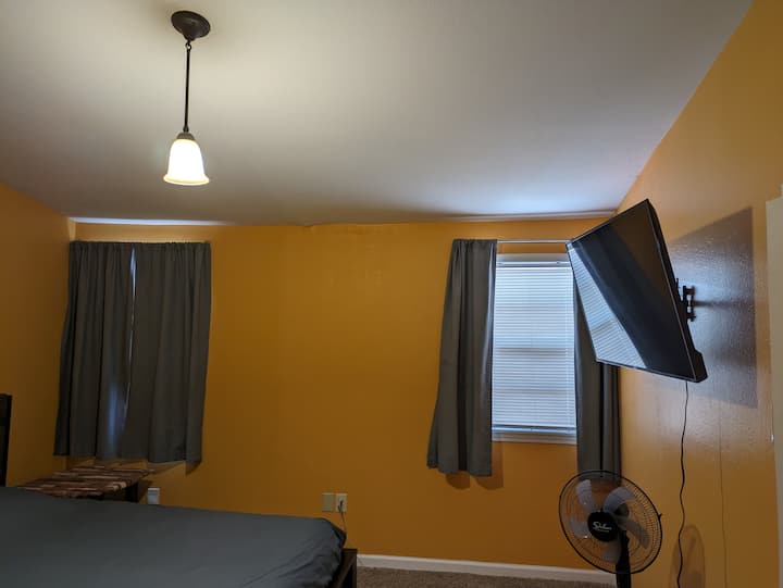 ห้องนอนหลักเตียงควีนไซส์ผ้าม่านวิวสมาร์ททีวี Roku ขนาด 50 นิ้ว ตอนนี้ห้องนอนมีพัดลมเพดาน