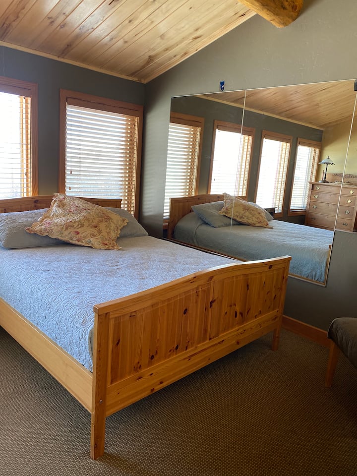 Este dormitorio tiene una cama queen y dos camas individuales con una cantidad decente de espacio para todos los huéspedes.